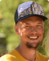 A smiling man with cap and beard.